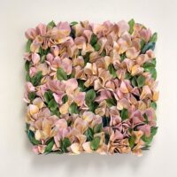 The "New Moon" wall art displays numerous pink and yellow ceramic flowers with green leaves arranged together on a plain white background.